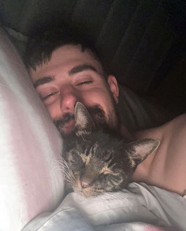 man sleeping with cat