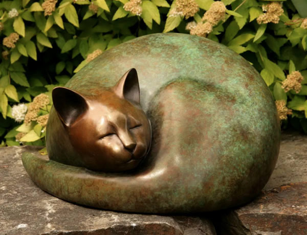 curled bronze cat sculpture