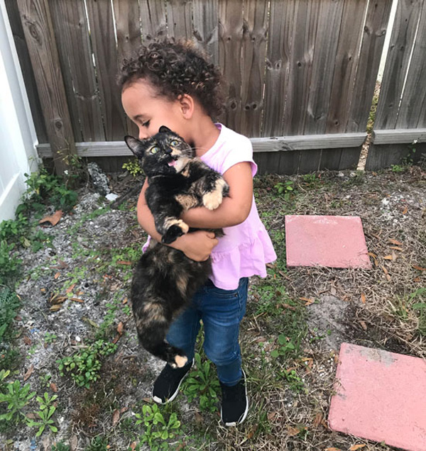 kid hugging cat too hard